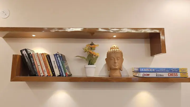 Lit wooden bookshelf with books and board games
